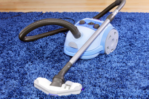 Vaccum cleaner on blue carpet used for our housecleaning services